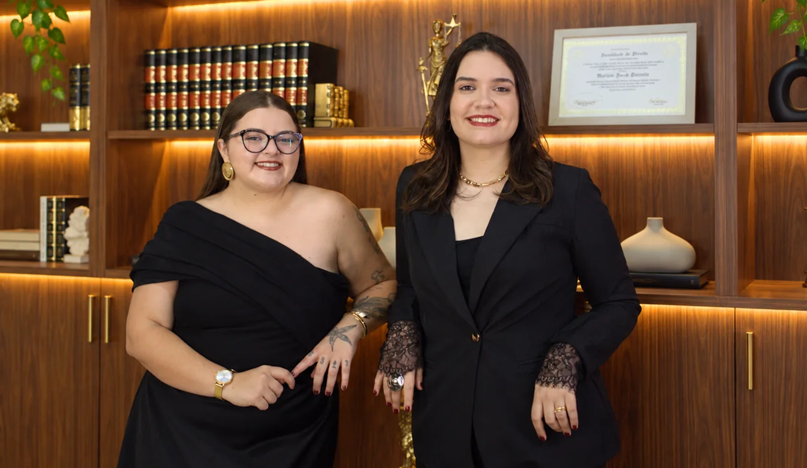 Duas profissionais em frente à estante do escritório